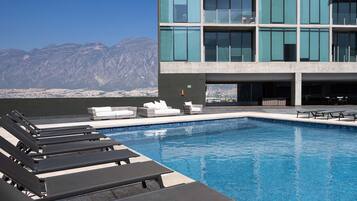 A modern outdoor pool with loungers and sweeping panoramic views (Pool towels not provided).