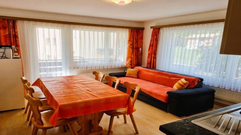 Un comedor con una mesa, sillas, un sofá y un radiador.