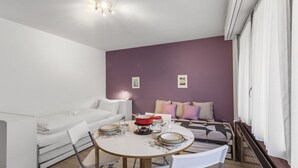 En kompakt bolig med spiseplads, sofa og seng.