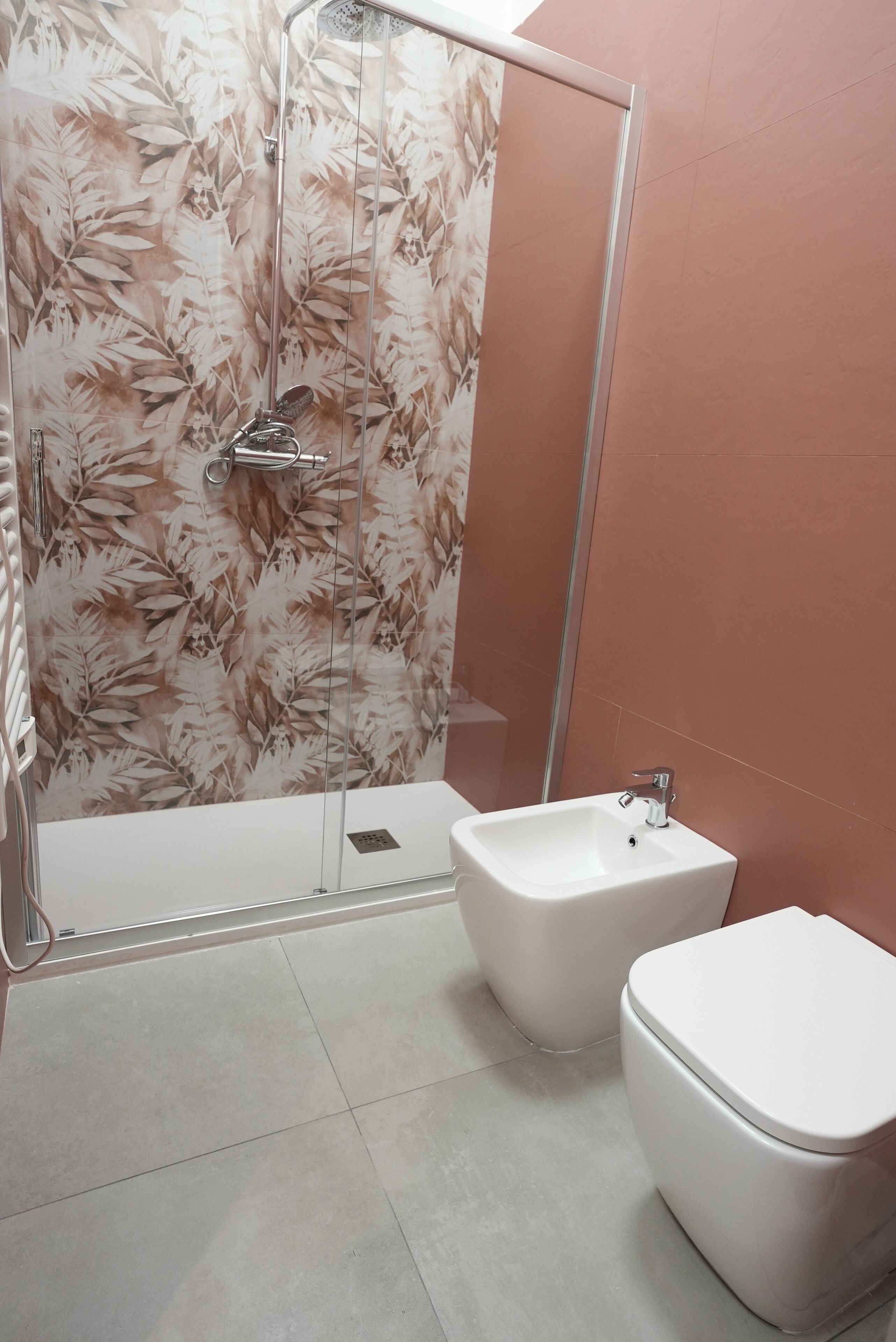 Ein Badezimmer mit Dusche, Bidet und Toilette.