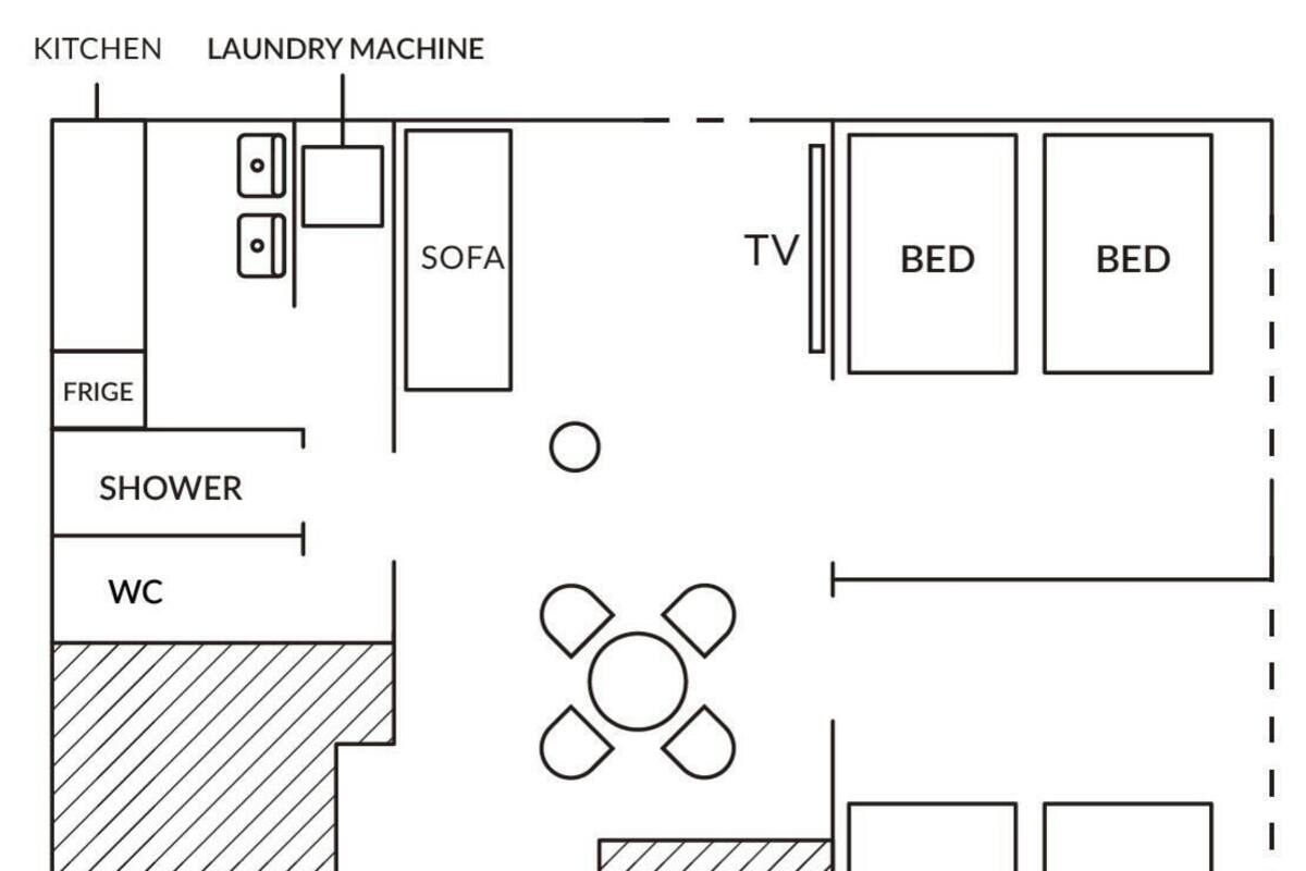 A floor plan with a kitchen, laundry machine, sofa, TV, two beds, a shower, and a WC.