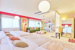 A modern hotel room with a large bed, a green sofa, and a dining area. - TORA HOTEL Okachimachi (Tokyo)