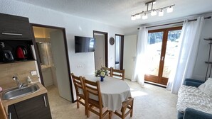 A compact room with a kitchenette, a dining area, and a bed. - Functional apartment near slopes, ideal for 4-6 people (Le Lioran)