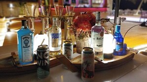 A bar area with various bottles and cans, including Absolut Vodka, Bacardi, and Bacardi Carta. - Easy Backpackers Paradise (Sihanoukville)