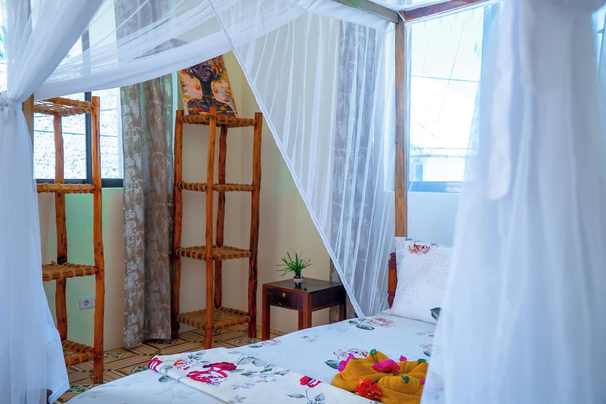 Une pièce avec un lit, une petite table et une chaise.