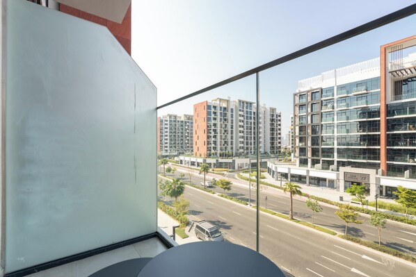A modern building with a glass facade, a clear view of the street, and a sign indicating the building's name and number.