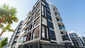Een modern hoog gebouw met meerdere balkons en grote ramen.