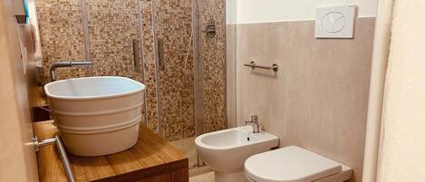 A bathroom with a large sink, a bidet, and a toilet.