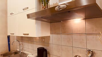 A modern kitchen with a stainless steel range hood, a coffee maker, and a toaster on the counter.