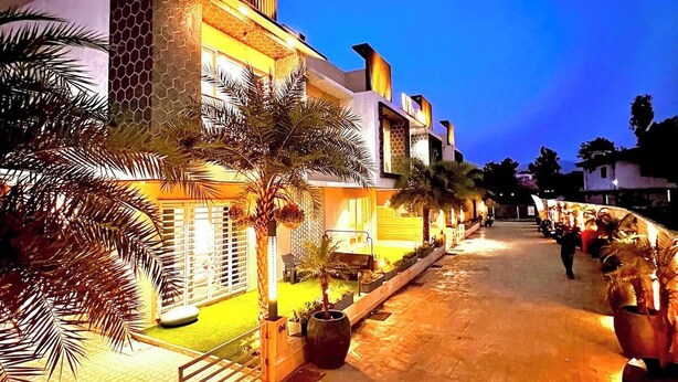 A modern building with a geometric facade, a paved walkway, and palm trees. - Ashford 4 BHK With Pvt Pool By Stellar Stays (Mawal)