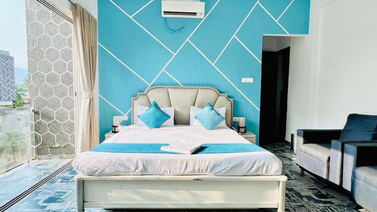 Een moderne slaapkamer met een groot bed, een sofa en stadszicht.