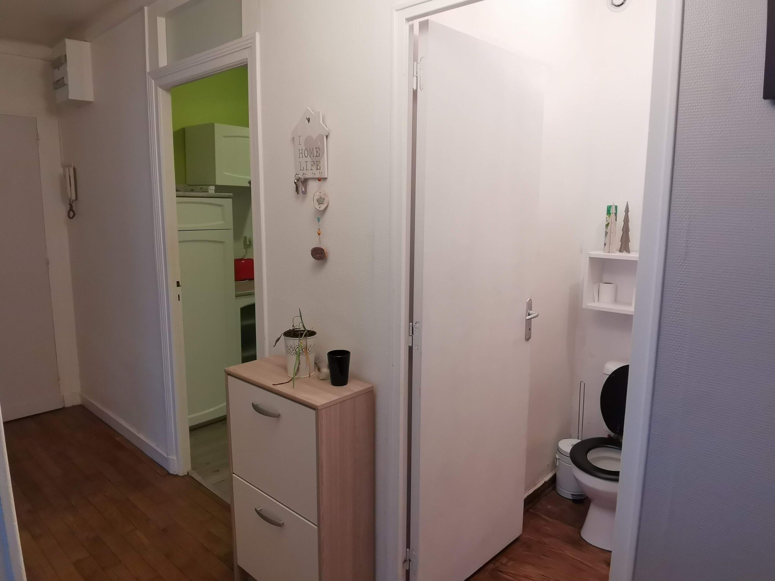 A small, clean bathroom with a toilet, a sink, and a cabinet.