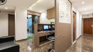 A modern hotel lobby with a reception desk, a computer, and a bar area. - HOTEL METROMAX (Mumbai)