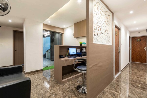 A modern hotel lobby with a reception desk, a computer, and a bar area. - HOTEL METROMAX (Mumbai)