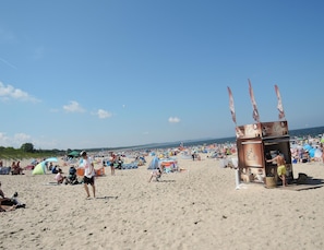Una playa con un puesto de café y sombrillas.