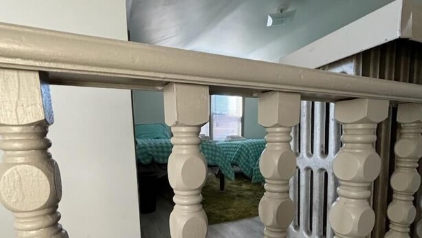 A staircase with a beige balustrade leading to a room with a green checkered bedspread. - The Kennywood Suite - The Blue Racer Car (Duquesne)