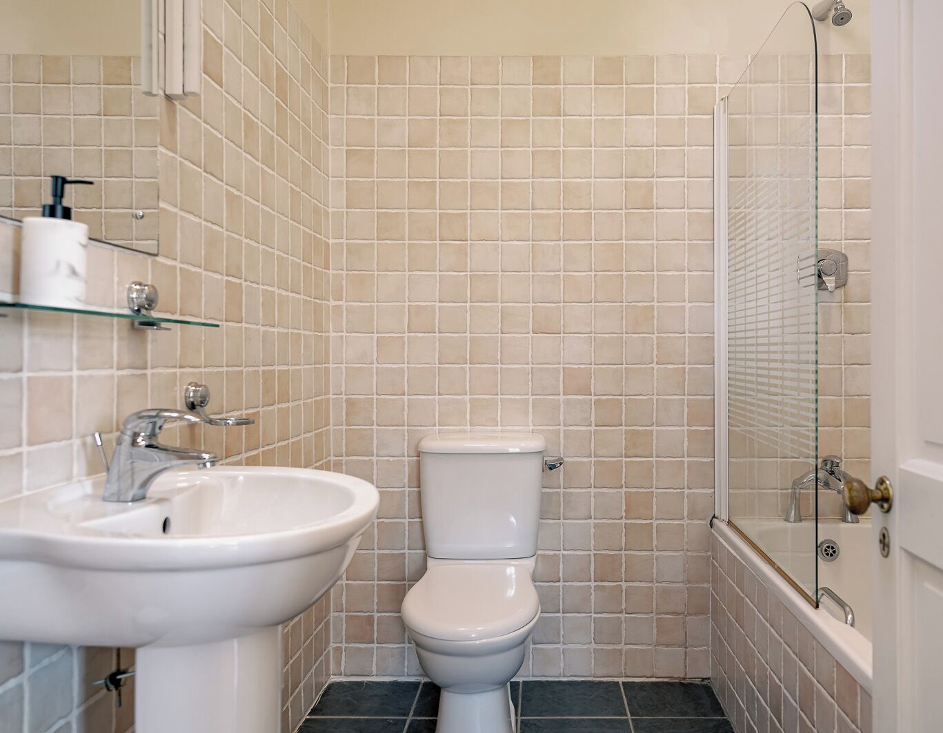 A bathroom with a sink, toilet, and shower.