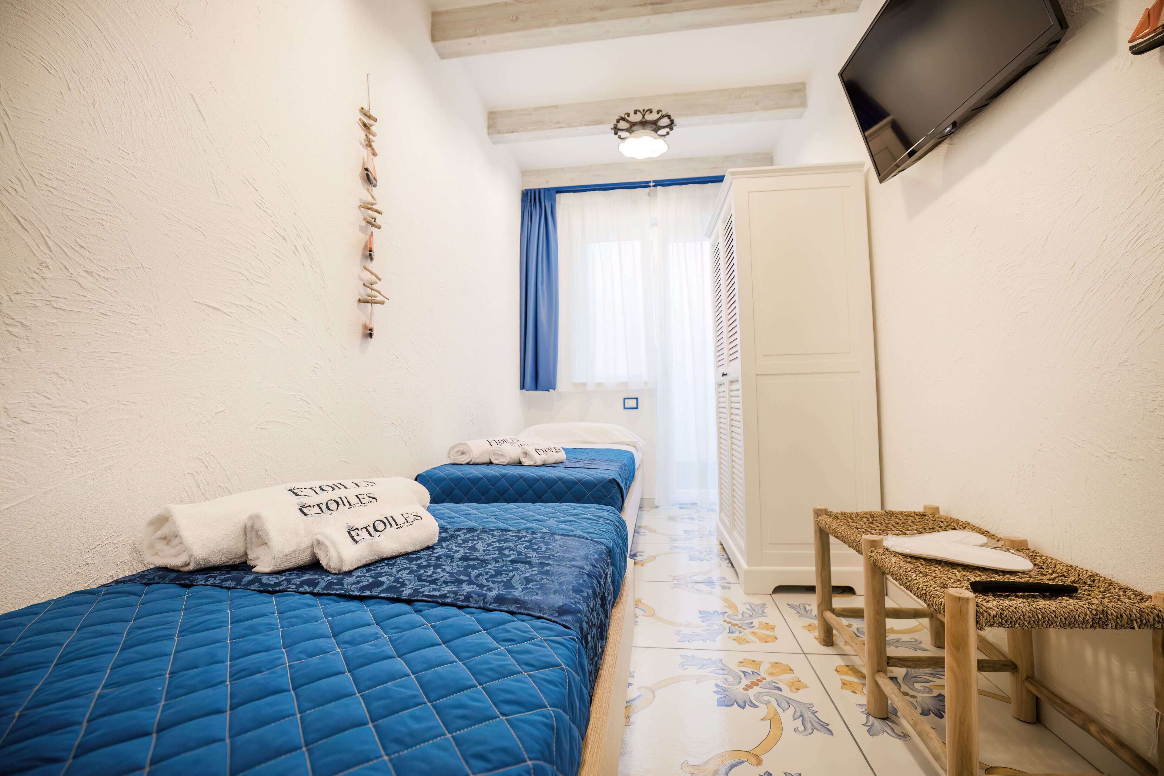 A bedroom with two beds, a TV, and a small table.