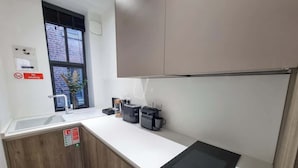 Une cuisine moderne dotée d’une cuisinière intégrée, d’un évier et d’armoires en bois.