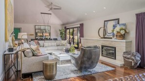 Uma sala de estar moderna com lareira, um conjunto de sofá, uma mesa de centro e uma janela grande.