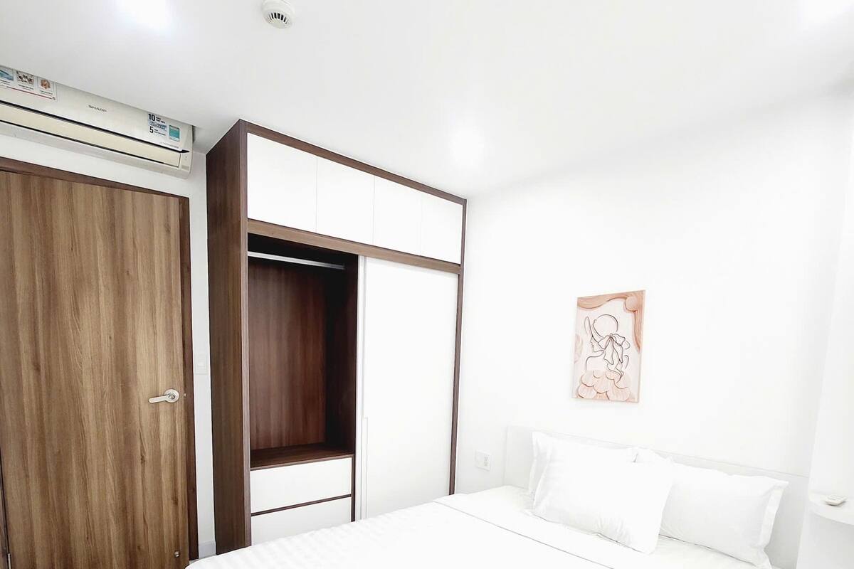 Une chambre à coucher comprenant un lit, une armoire et un climatiseur fixé au mur.