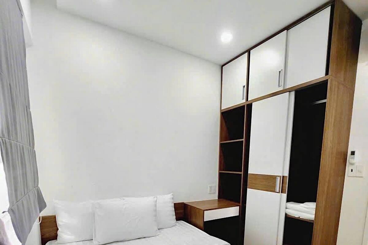 Une chambre à coucher avec un grand lit, une armoire en bois et une table de chevet.