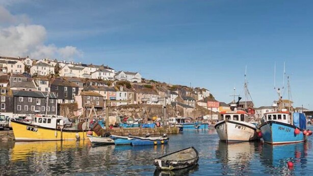 A harbor with boats docked, a hillside of buildings, and calm water. - Upper Deck, The Upper Deck - Unique Harbourside 2Bed apartment with FREE Parking (Mevagissey)