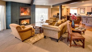 A living room with a fireplace, sofas, a coffee table, and a dining area in the background. - 4BR Townhome | Private Hot Tub, 3.5 Bathrooms. Spa (Redmond)