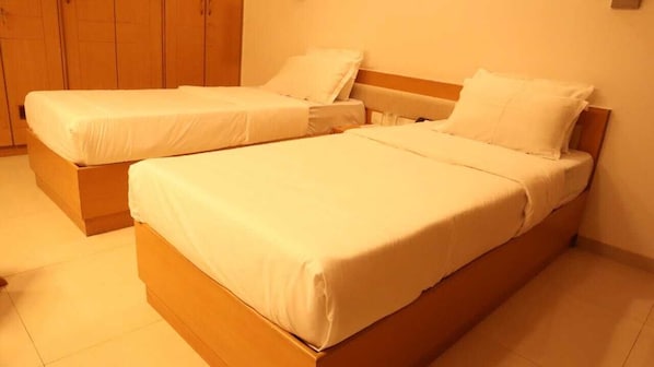 A room with two single beds, wooden headboards, and a tiled floor. - Arogyadham Swasthya Kutir (Majhgawan)