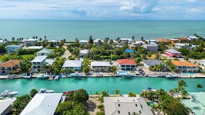 An aerial view of a coastal residential area with houses, a marina, and a clear view of the ocean. - Duck Key Livin in Paradise with a heated pool 75 ft of dockage 2 paddleboards (Marathon)