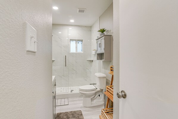 Un bagno moderno con toilette, lavandino e zona doccia.