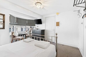 A bedroom with a bed, a desk, a chair, a TV, and a wardrobe. - Brighton Beachside Ensuite – Steps from Pier (Brighton and Hove)
