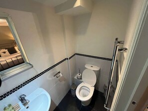 Un baño pequeño con inodoro, lavabo y espejo.