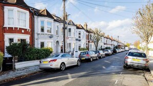 A row of terraced houses with parked cars on the street. - Modern Living Meets Timeless Charm (Greater London)
