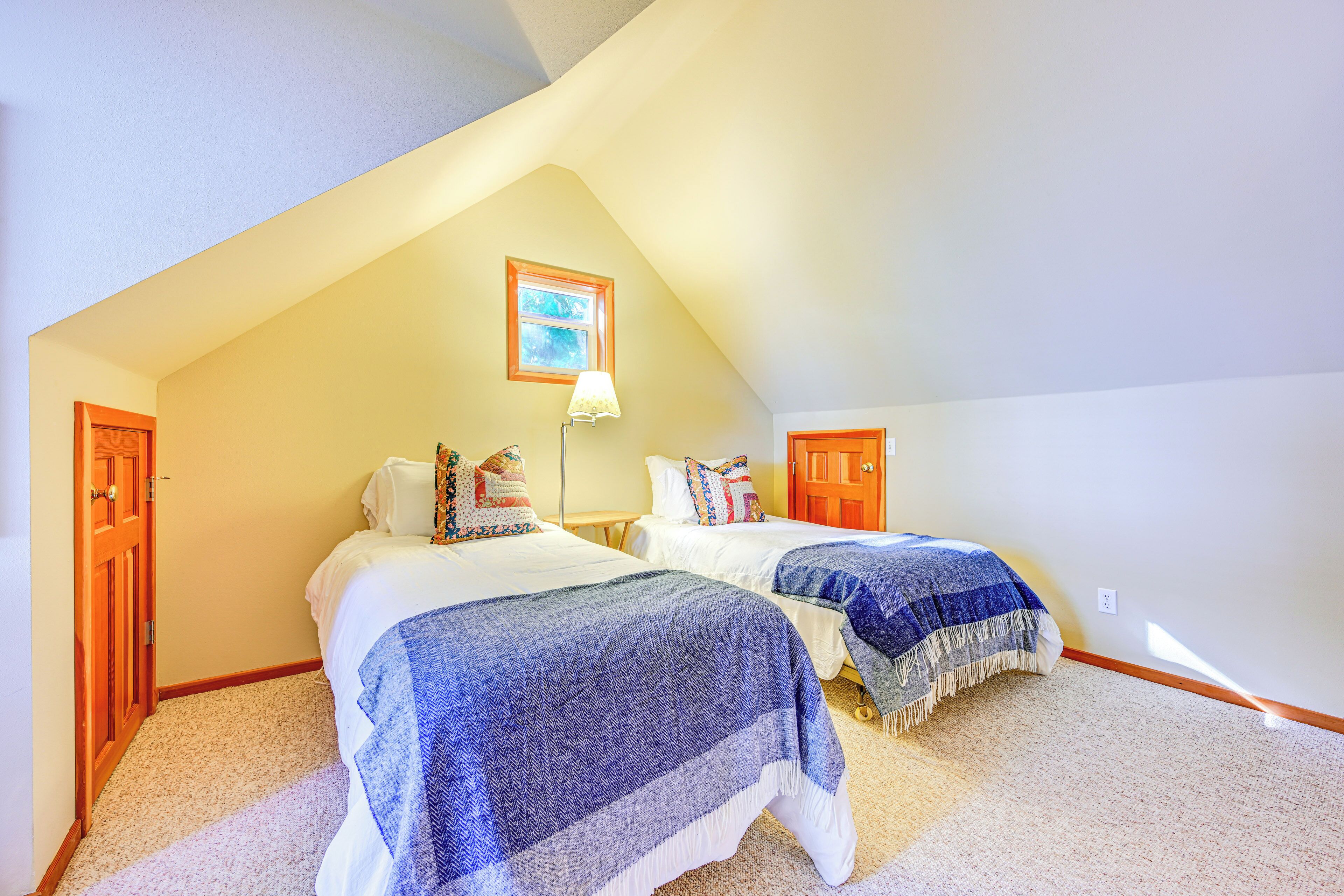 Un dormitorio con dos camas, una ventana y una puerta.