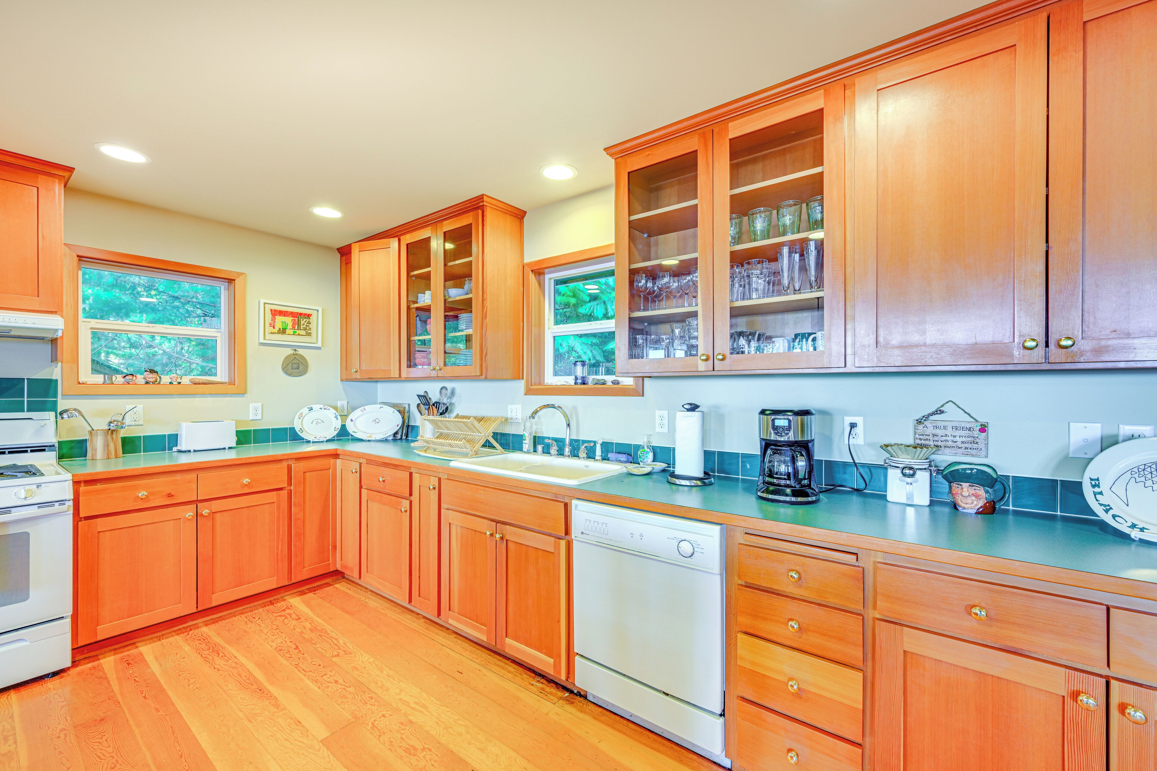 A kitchen with wooden cabinets, a dishwasher, and a sink.