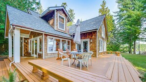 Une cabane en bois dotée d’une terrasse, d’un espace salon extérieur et d’un patio couvert.