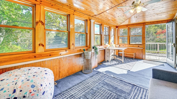 A wooden cabin with large windows, a ceiling fan, a desk, and a chair. - Pet-friendly Catskills Retreat: Fire Pit & Deck! (Grand Gorge)