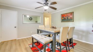A dining area with a table, chairs, a ceiling fan, a mirror, and a painting on the wall. - Family Home w/ Deck & Game Room in Stockbridge! (Stockbridge)