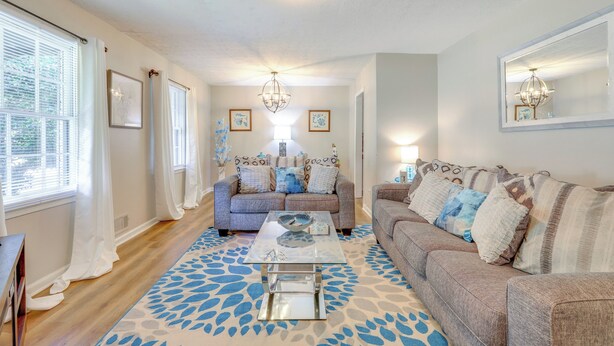 A living room with a sofa, coffee table, and patterned rug. - Family Home w/ Deck & Game Room in Stockbridge! (Stockbridge)