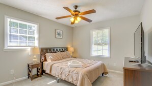 A bedroom with a bed, nightstands, a ceiling fan, and a TV. - Family Home w/ Deck & Game Room in Stockbridge! (Stockbridge)