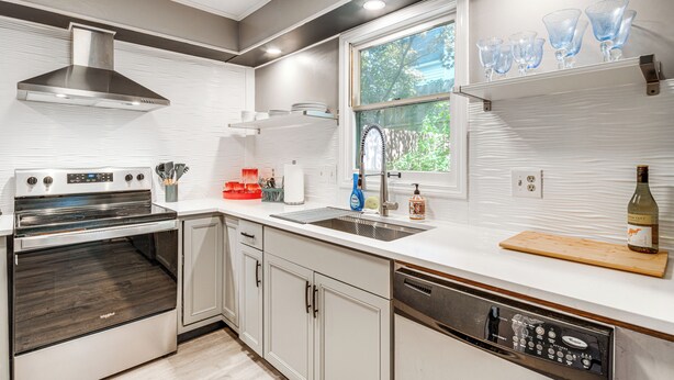 A modern kitchen with stainless steel appliances, a dishwasher, and a window with a view of greenery. - Walk to Main St Hendersonville: Chic Home w/ Yard (Hendersonville)
