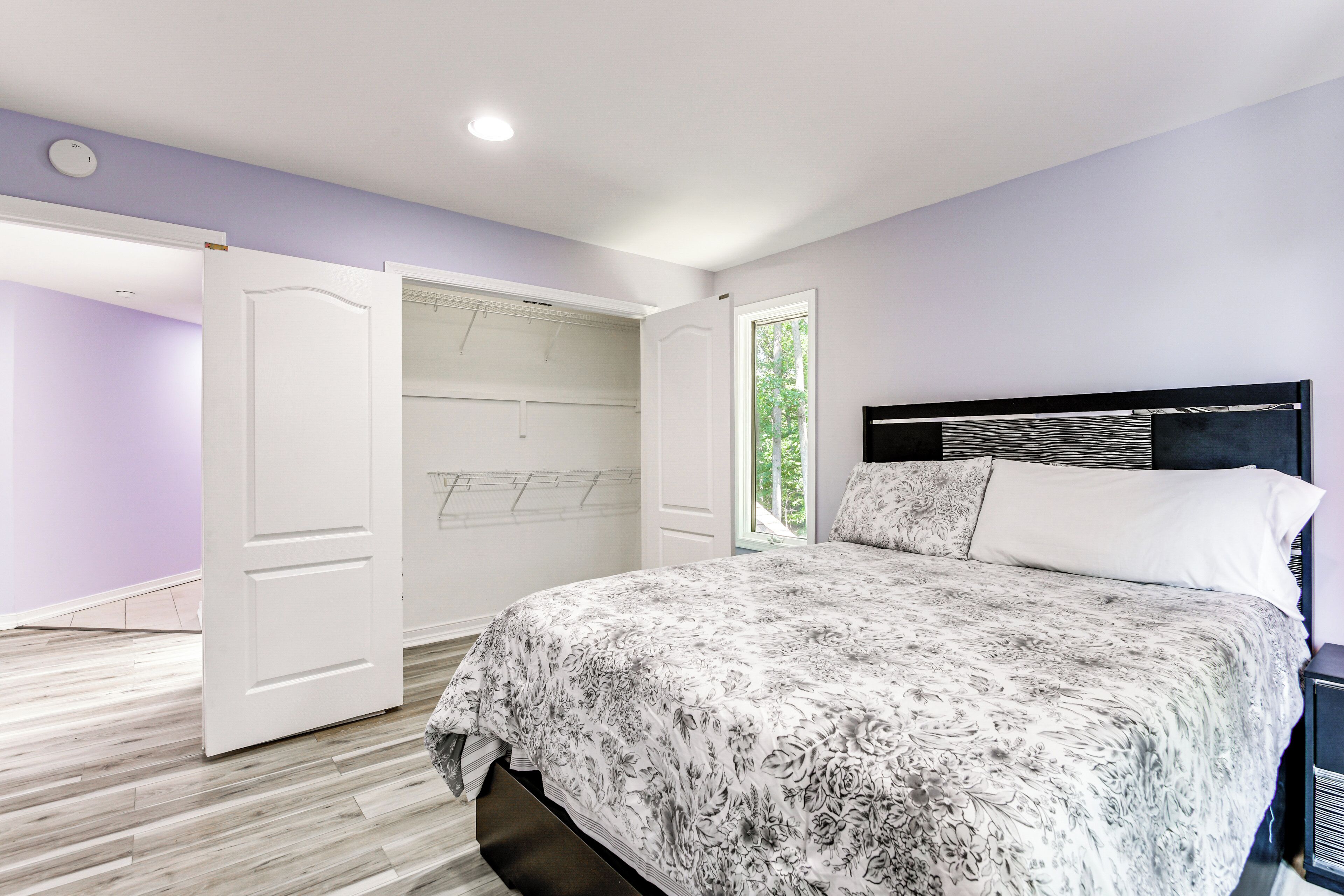 Une chambre à coucher avec un lit, une armoire et une fenêtre.