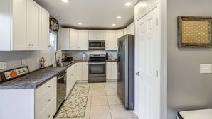 A kitchen with white cabinets, a stainless steel refrigerator, a microwave, and an oven. - 1/2 Mi to Creation Museum: Home w/ Large Yard! (Petersburg)