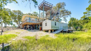 Ein zweistöckiges Haus mit einer Holzterrasse und einer kleinen Veranda.