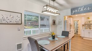 Comedor con mesa de madera, sillas y una lámpara colgante.