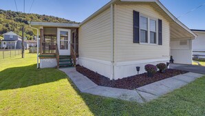 A single-story house with a front porch, a covered entryway, and a small front yard with a flower bed. - Paden City Home Near Ohio River! (Paden City)
