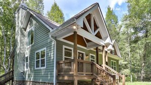 A two-story house with a wooden deck and a stone foundation. - Cascading Falls Retreat by Mountain Oasis | Mountaintown Creek Views (Ellijay)