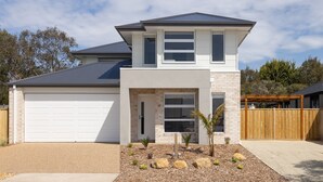 A modern two-story house with a garage, a covered patio, and a landscaped front yard with rocks and small plants. - SaltCove with spa in Cowes (Cowes)