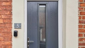 A door with a number plate '5' and a doorbell.